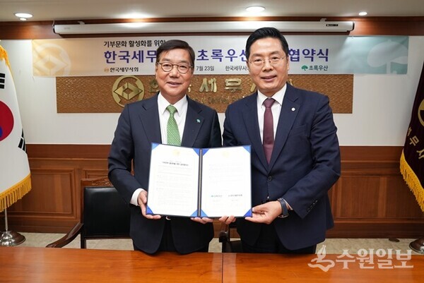 구재이 한국세무사회장(오른쪽)과 황영기 초록우산 어린이재단 회장이 업무협약을 체결한 뒤 기념촬영을 하고 있다. (사진=한국세무사회)