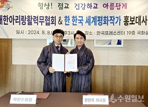 한한국 세계평화작가(오른쪽)가 박천수 (사)대한아리랑활력무협회 회장(왼쪽)으로부터 (사)대한아리랑활력무협회 홍보대사 위촉장을 받은 뒤 기념촬영을 하고 있다. (사진=한한국세계평화작가) 