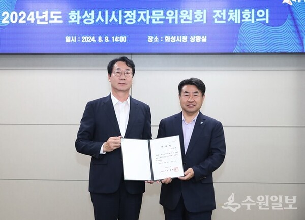 정명근 화성시장(왼쪽)이 이원희 한경국립대학교 총장에게 신규 위원 위촉장을 전달하고 있다. (사진=화성시)