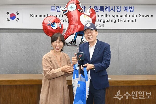 이재준 수원시장이 이비아 사랑방 대표와 선물을 주고 받으며 환하게 웃고 있다. (사진=수원시)