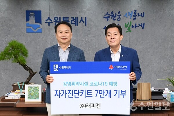 이재준 수원시장(오른쪽)이 박재구 ㈜래피젠 대표(왼쪽)로부터 자가진단키트 전달받은 후 기념촬영을 하고 있다. (사진=수원시)