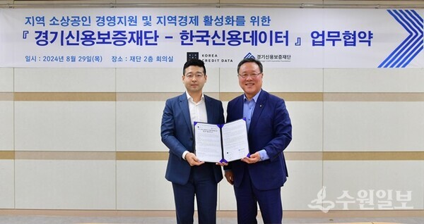 시석중 경기신용보증재단 이사장(오른쪽)과 김동호 한국신용데이터 대표이사가 업무협약을 체결한 뒤 기념촬영을 하고 있다. (사진=경기신보)