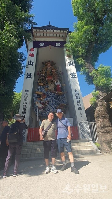 사진 2-4, 하카타 마츠리 때 사용한 가마. 매년 7월에 하카다 기온 마츠리가 열리는데 이때 각 마을에서 만들어진 가마를 심사하여 가장 잘 만들어진 가마를 시상하고 쿠시타 신사에 보관하고 있다. 가마앞에서 필자와 아버지 김충영님이 함께 찍었다. (사진=화성연구회)