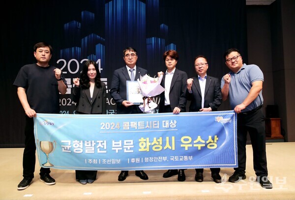 손임성 화성시 부시장(왼쪽 세번째)이 ‘2024년 콤팩트시티 대상’에서 균형발전 부문 우수상을 수상한 뒤 이용범 홍보담당관(오른쪽 두번째) 및 관계공무원들과 기념촬영을 하고 있다. (사진=화성시) 