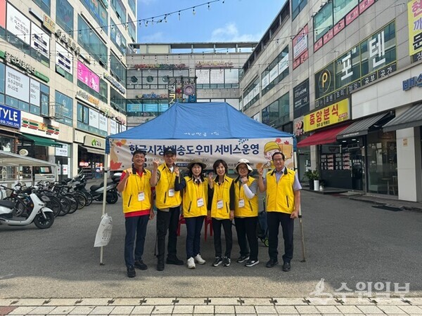 여주시가 한글시장 및 세종시장 상점가에서 운영하고 있는 ‘배송 도우미 부스’ 앞에서 관계자들이 기념촬영을 하고 있다. (사진=여주시)