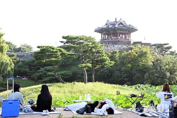 시민들이 수원화성 방화수류정이 보이는 용연에서 가을 피크닉을 즐기고 있다.(사진=수원시)