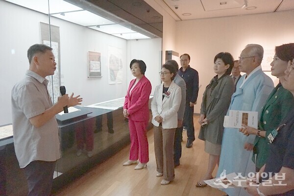 12일 열린 개막식에 참석한 신계용 과천시장 등 내빈에게 추사의 작품세계를 설명하는 허홍범 학예사.(사진=수원일보)