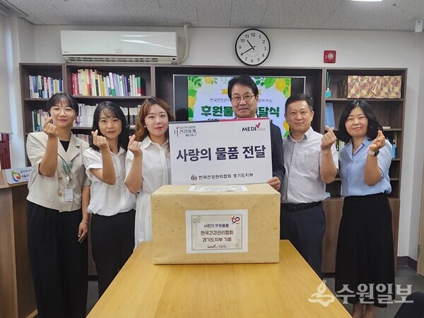 김계환 한국건강관리협회 경기도지부 본부장(오른쪽 세번째)이 수원시다문화가족지원센터에 사회공헌 후원물품을 전달한 뒤 관계자들과 기념촬영을 하고 있다. (사진=건협 경기도지부)