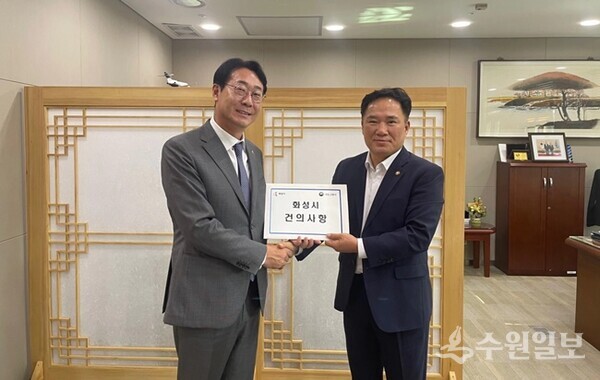 정명근 화성시장(왼쪽)이 백원국 국토교통부 2차관에게 화성시 현안사항 건의서를 전달하며 포즈를 취하고 있다. (사진=화성시)