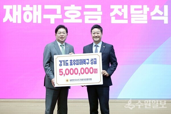 김진경 경기도의회 의장(오른쪽)이 안성민 대한민국 시도의회 의장협의회 회장으로부터 경기도의 호우 피해 복구를 위한 성금을 전달받고 있다. (사진=경기도의회)