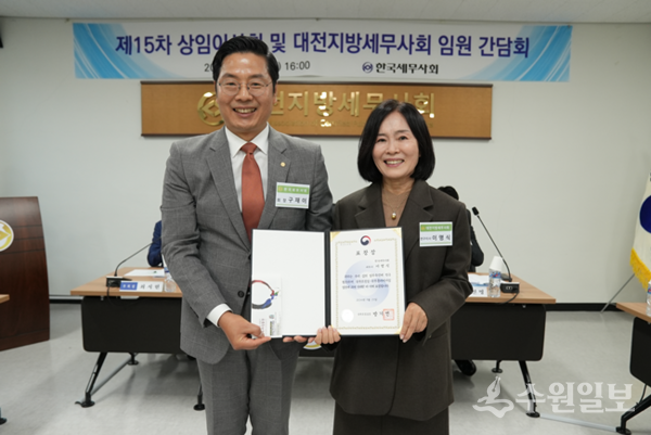 구재이 한국세무사회 회장(왼쪽)이 이명식 세무사에게 국무조정실장 표창장을 전달한 뒤 기념촬영을 하고 있다. (사진=한국세무사회)