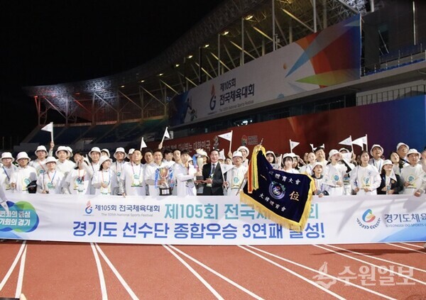 ‘제105회 전국체육대회’에서 종합우승 3연패를 달성한 이원성 경기도 선수단 단장(경기도 체육회장)이 선수, 임원들과 함께 우승기와 트로피를 들고 기쁨을 나누고 있다. (사진=경기도 체육회)