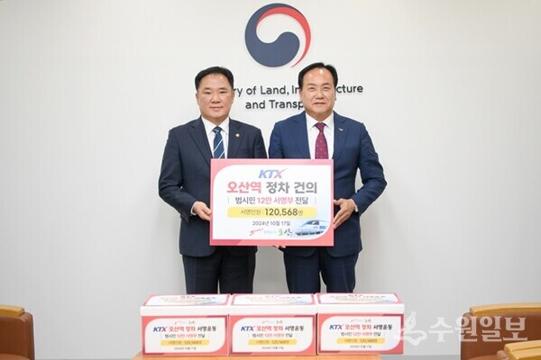 이권재 오산시장(오른쪽)이 백원국 국토교통부 제2차관에게 ‘KTX 오산역 정차건의 범시민 서명운동’에 참여한 12만568명의 서명부를 전달하고 있다. (사진=오산시)