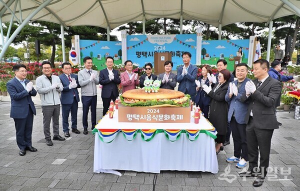 '2024년 평택시 음식문화축제'에서 정장선 평택시장(왼쪽 6번째)을 비롯한 지역 내빈들이 1.2m의 대형 햄버거 제작 퍼포먼스를 갖기 전 기념촬영을 하고 있다. (사진=평택시)