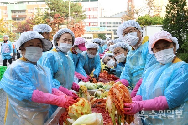 김세제 화성시자원봉사센터 이사장(오른쪽 두번째)이 자원봉사자들과 함께 김장을 담그고 있다. (사진=화성시자원봉사센터)