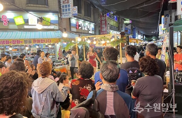 문화관광형시장으로 육성되고 있는 북수원시장에서 장을 보던 시민들이 공연을 즐기고 있다.(사진=수원시)