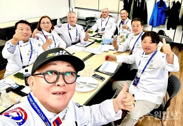 시계방향으로 몽골 국제심사위원 미코미코(앞쪽 맨앞 첫번째), 장명하 교수(왼쪽 첫번째)교수, 몽골 국제심사위원 뷸란다라이(왼쪽 두번째),독일 국제심사위원 스테판 뮬러(왼쪽 세번째), 스위스 국제심사위원 일람파머(왼쪽 네번째), 몽골 국제심사 위원 츄월슘(왼쪽 다섯번째), 홍콩 국제심사위원 바바토(왼쪽 여섯번째), 국제심사위원 임종우교수(왼쪽 일곱번째)가 심사를 마친뒤 심사위원실에서 기념촬영을 하고 있다..(사진=국제심사위원회)