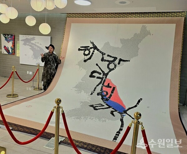 한한국 세계평화작가가 애기봉평화생태공원 오픈갤러리에서 열리고 있는 ‘애기봉에서 울리는 세계평화전’에서 '희망대한민국(헌법기록화)' 작품을 설명하고 있다. (사진=한한국 작가)