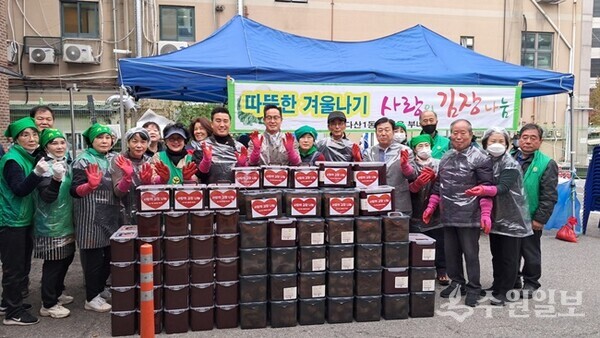 남양주시 다산1동 새마을부녀회 임선자 회장과 회원, 이기복 다산행정복지센터장 , 후원단체 회원 등이 정성껏 마련한 김장김치통 앞에서 기념촬영을 하고 있다. (사진=다산행정복지센터)