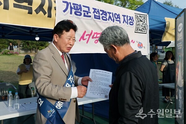 서태원 군수(왼쪽)가 접경지역 지정을 위한 서명운동에 나서고 있다. (사진=가평군)