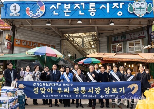 시석중 경기신용보증재단 이사장이 21일 군포시 산본전통시장에서 소상공인 단체 및 금융기관 관계자들과 함께 ‘전통시장 활성화를 위한 설맞이 장보기 행사'를 진행하면서 기념촬영을 하고 있다.(사진=경기신보)