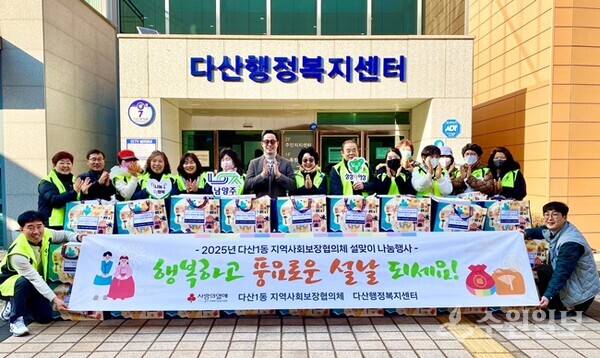 이기복 다산행정복지센터장(가운데)이 남양주시 다산1동 지역사회보장협의체 설맞이 나눔행사에서 위원들과 함께 기념촬영을 하고 있다. (사진=남양주시 다산 1동)