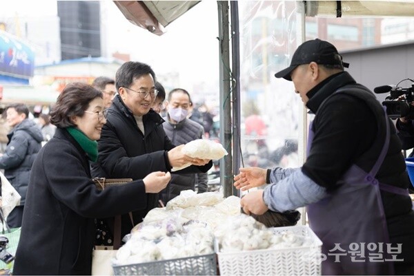 26일 오후 김동연 경기도지사와 부인 정우영씨가 설맞이 의왕도깨비시장을 방문, 떡 등을 구매하고 있다. (사진=경기도)