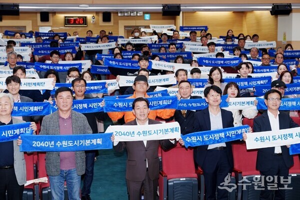 지난 2023년 11월4일 개최된 2040 수원 도시기본계획(안) 공청회에서 이재준 수원시장과 도시계획단 참여 시민들이 손팻말을 들고 있다.(사진=수원시)