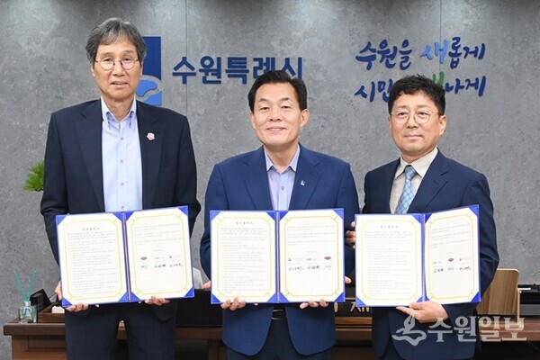 지난해 7월 이재준 수원시장(가운데, 수원시자원봉사센터 이사장)과 최순호 수원FC 단장, 김상연 수원경제정의실천시민연합 공동대표가 새벽빛 장애인 야학 지원을 위한 업무협약 후 기념촬영을 하고 있다.(사진=수원시)