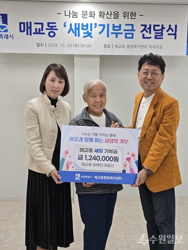 매교동 주민인 유복단 할머니(가운데)가 폐지를 팔아 모은 금액을 새벽빛 장애인학교 이전을 위해 기부하고 있다.(사진=수원시)
