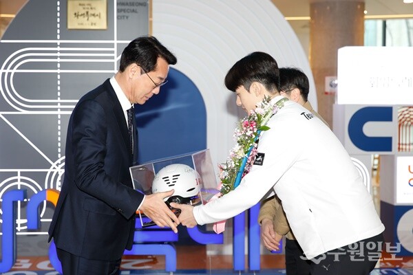 정명근 화성시장(왼쪽)이 쇼트트랙 국가대표들의 사인이 표기된 기념헬멧을 증정받고 있다. (사진=화성시)