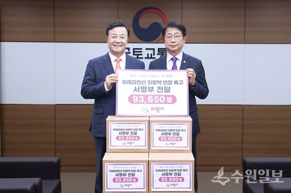 김성제 의왕시장(왼쪽)이 14일 박상우 국토교통부장관에게 ‘위례과천선 의왕연장’ 추진을 위한 주민 서명부를 전달한 뒤 기념촬영을 하고 있다. (사진=의왕시)
