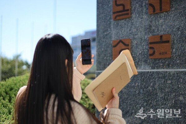 관광객이 투어 콘텐츠 ‘수원역’ 게임을 하고 있다.(사진=수원시)