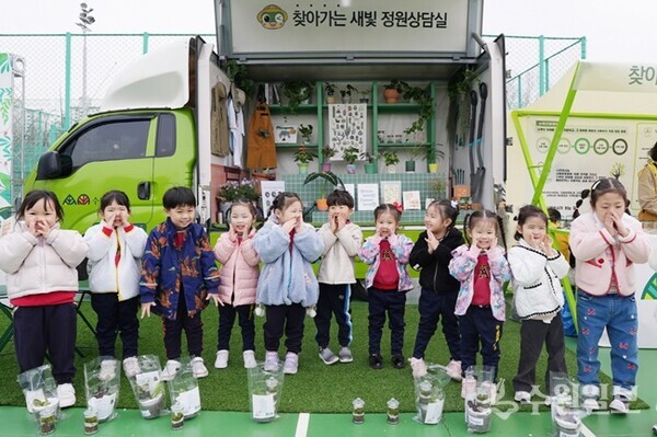 찾아가는 새빛 정원상담실 앞에서 어린이들이 기념촬영을 하고 있다.(사진=수원시)