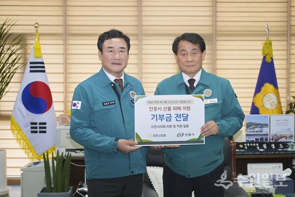 박명서 이천시의회 의장(왼쪽)이 김경도 안동시의회 의장에게 성금을 전달한 뒤 기념촬영을 하고 있다. (사진=이천시의회)