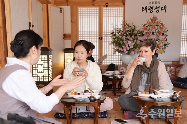 수원 화성행궁 별주에서 열리는 세계유산 활용 프로그램 ‘수원화성 태평성대’ 참가자들이 혜경궁 궁중 다과 체험을 하고 있다.(사진=수원시)