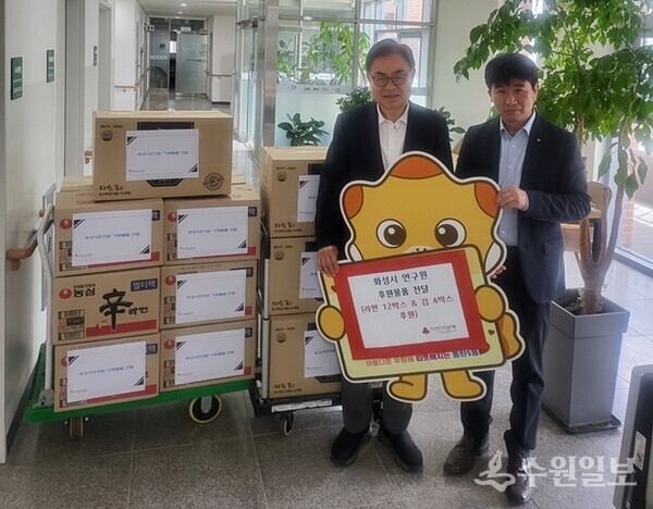 박철수 화성시연구원장(왼쪽)이 23일 동탄5동행정복지센터를 방문, 관내 어려운 이웃들을 위해 라면 12박스와 김 4박스를 기부하고 있다. (사진=화성시연구원)