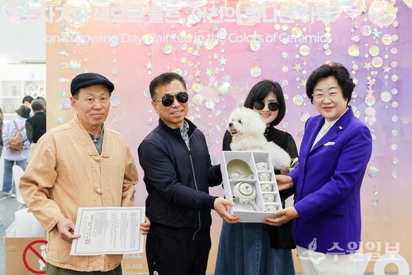 100만번째 입장의 주인공으로 당첨된 별이네 가족에게 유기정 이천시 도자기 명장이 5인 다기 세트를 전달한 뒤 김경희 이천시도자기축제추진위원회 위원장(오른쪽)과 기념촬영을 하고 있다. (사진=이천시)