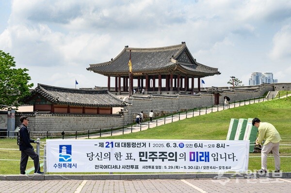 수원시 관계자들이 투표 참여를 독려하는 문구가 적힌 현수막을 설치하고 있다. (사진=수원시)