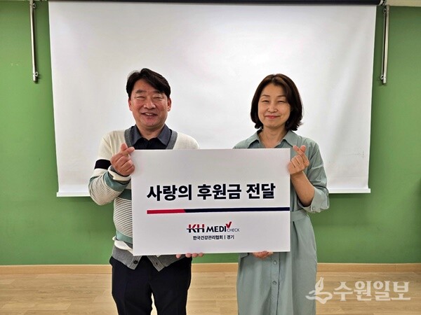 성동진 한국건강관리협회 경기도지부 전략사업부장(왼쪽)이 위은미 수원드림스타트팀장에게 사회공헌 후원금을 전달한 뒤 기념촬영을 하고 있다. (사진=건협 경기도지부)