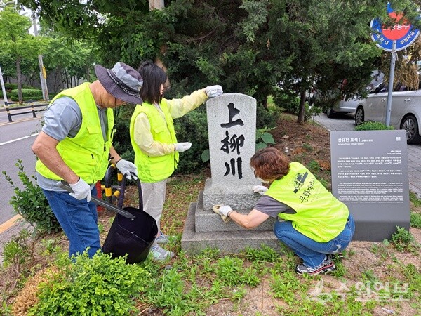 연구소 회원들이 상유천 표석 주변 환경 정화를 실시하고 있다. (사진=이야기가 있는 역사문화연구소)