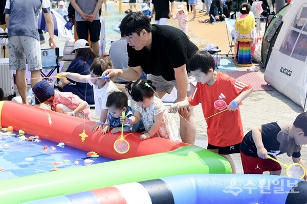 축제장을 찾은 가족 단위 관람객들이 낚시놀이 프로그램에 참여하고 있다. (사진=화성시)