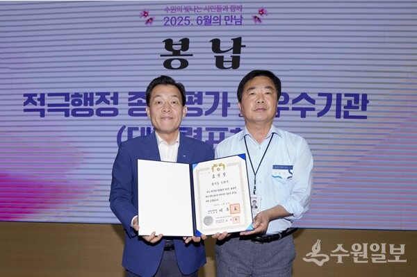 이재준 수원시장(왼쪽)이 9일 시청 중회의실에서 열린 ‘6월의 만남’ 행사 중에 전용기 수원시 법무담당관으로부터  대통령 표창장을 봉납받고 있다. (사진=수원시)
