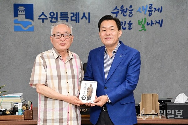 이재준 수원시장(오른쪽)과 박환 고려학술문화재단 이사장이 평전을 들고 기념 촬영을 하고 있다. (사진=수원시)