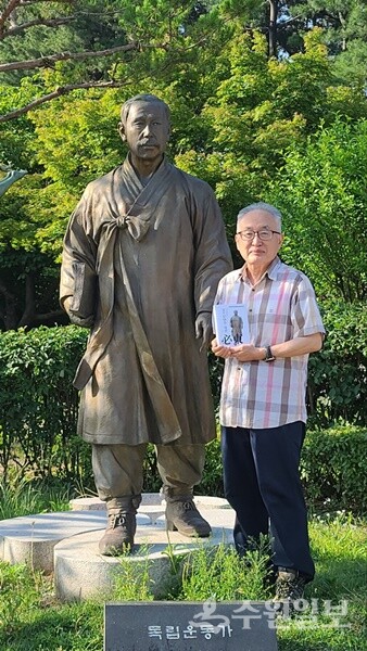 박환 이사장이 수원올림픽공원 필동 임면수 선생 동상에서 ‘필동 임면수 평전’을 헌정한 뒤 기념 촬영을 하고 있다. (사진=수원시)