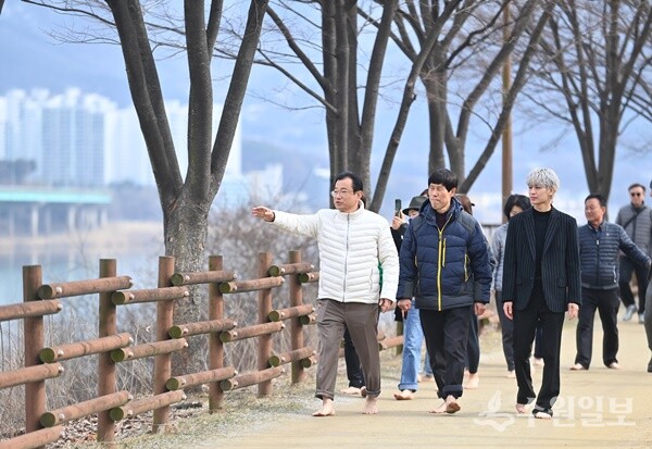 이현재 하남시장이 지난해 2월 보이그룹 아이콘(iKON) 멤버 송윤형씨와 함께 미사한강모랫길을 맨발로 걸으며 모랫길을 점검하고 있다. (사진=하남시)