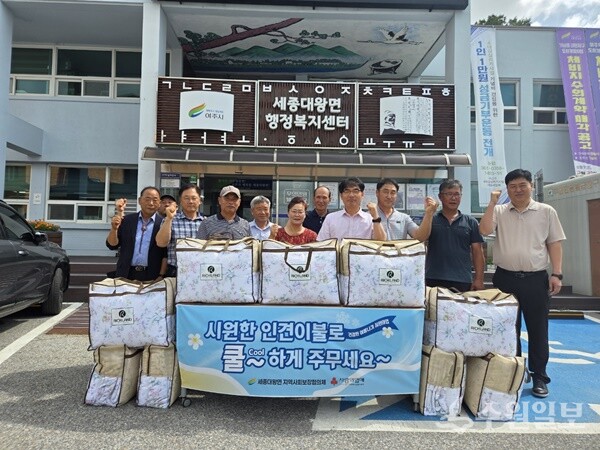 홍광래 세종대왕면장(오른쪽 네번째)이 취약 계층 20가구에 여름 이불을 지원한 뒤 관계자들과 함께 기념촬영을 하고 있다. (사진= 여주시)