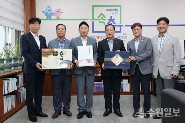 서태원 가평군수(왼쪽 세번째)와 이병선 속초시장(오른쪽 세번째)이 각 지자체 특산품중 하나인 오징어와 막걸리를 교환한 뒤 기념촬영을 하고 있다. (사진=가평군)