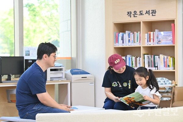 하남시청 민원실을 방문한 한 시민이 대기하는 동안 책을 읽을 수 있는 민원실 내 ‘작은 도서관’에서 아이와 함께 책을 읽고 있다. (사진=하남시)
