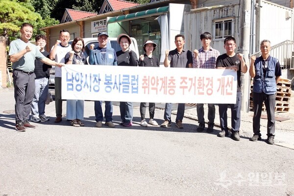 구리시 남양시장 골목상인회원들과 동구동 직원 등이 집수리봉사활동을 펼친 뒤 기념촬영을 하고 있다. (사진=폴리스타임즈)
